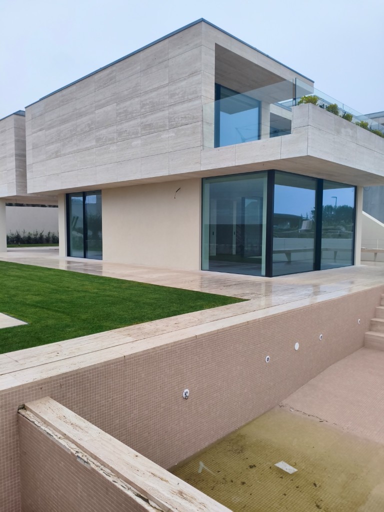 Exterior property photo before AI enhancement with flat lighting and empty pool area